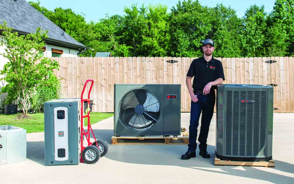 ClimateCare Tech in front of Trane HVAC units
